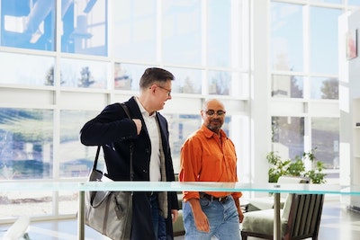 two men talking while walking