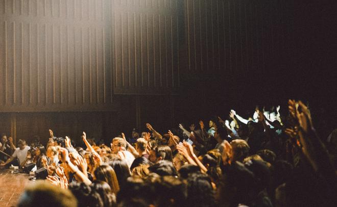 Students raising hands in a lecture hall